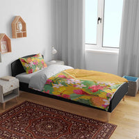 Yellow tropical floral duvet cover and two pillowcases on bed with multicolor flower print