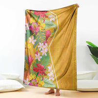 Yellow tropical flower blanket draped on sofa with colorful floral panel and back