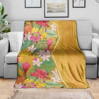 Yellow tropical flower blanket on grey sofa, floral print on one side and solid back
