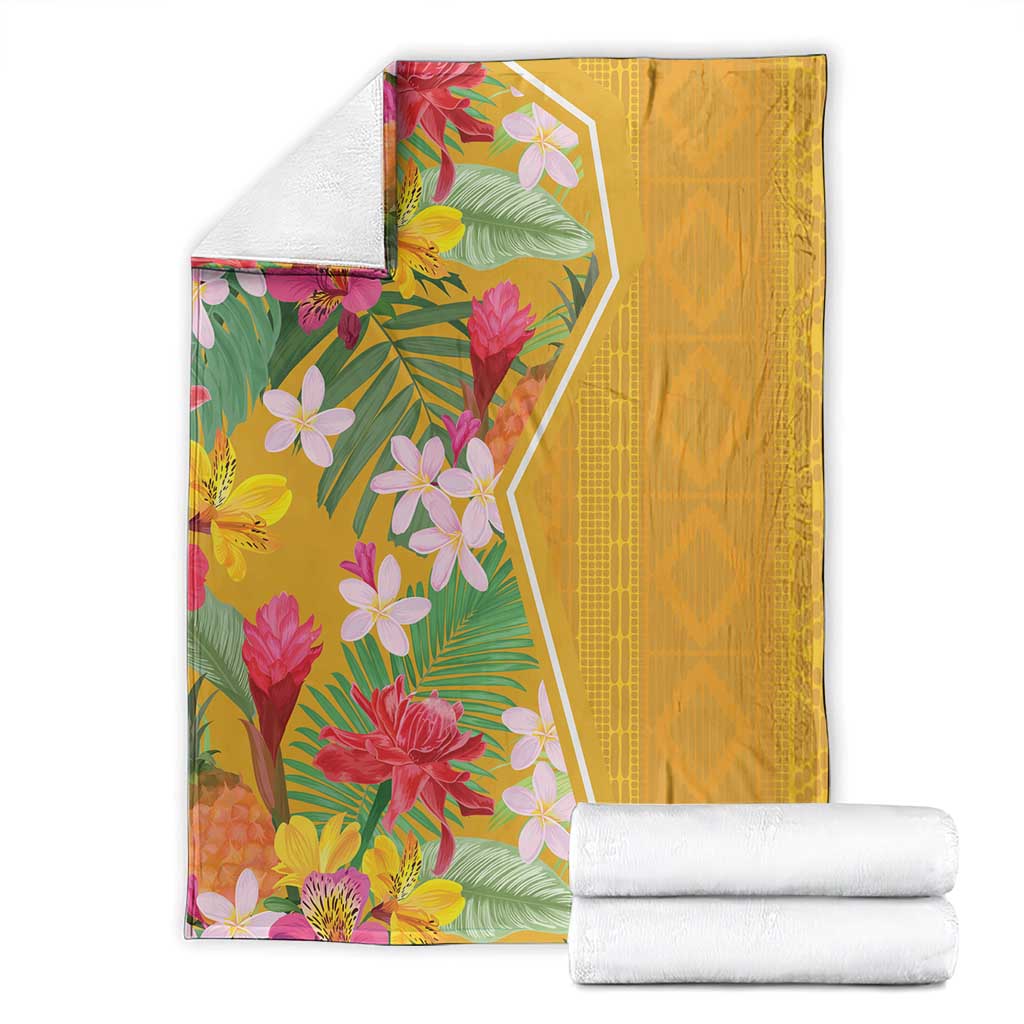 Yellow tropical flower blanket folded with bright floral print beside white rolled towels