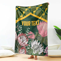 Personalized green blanket with kente-style zigzag band and large protea flower artwork