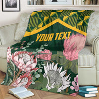 Personalized green blanket with kente zigzag border and pink-and-white protea floral print