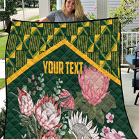 Green quilt with yellow kente-style border and pink protea floral print