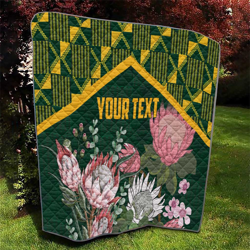Green quilt with yellow kente pattern border and large pink and white protea flowers