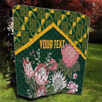 Green quilt with yellow kente pattern border and large pink and white protea flowers