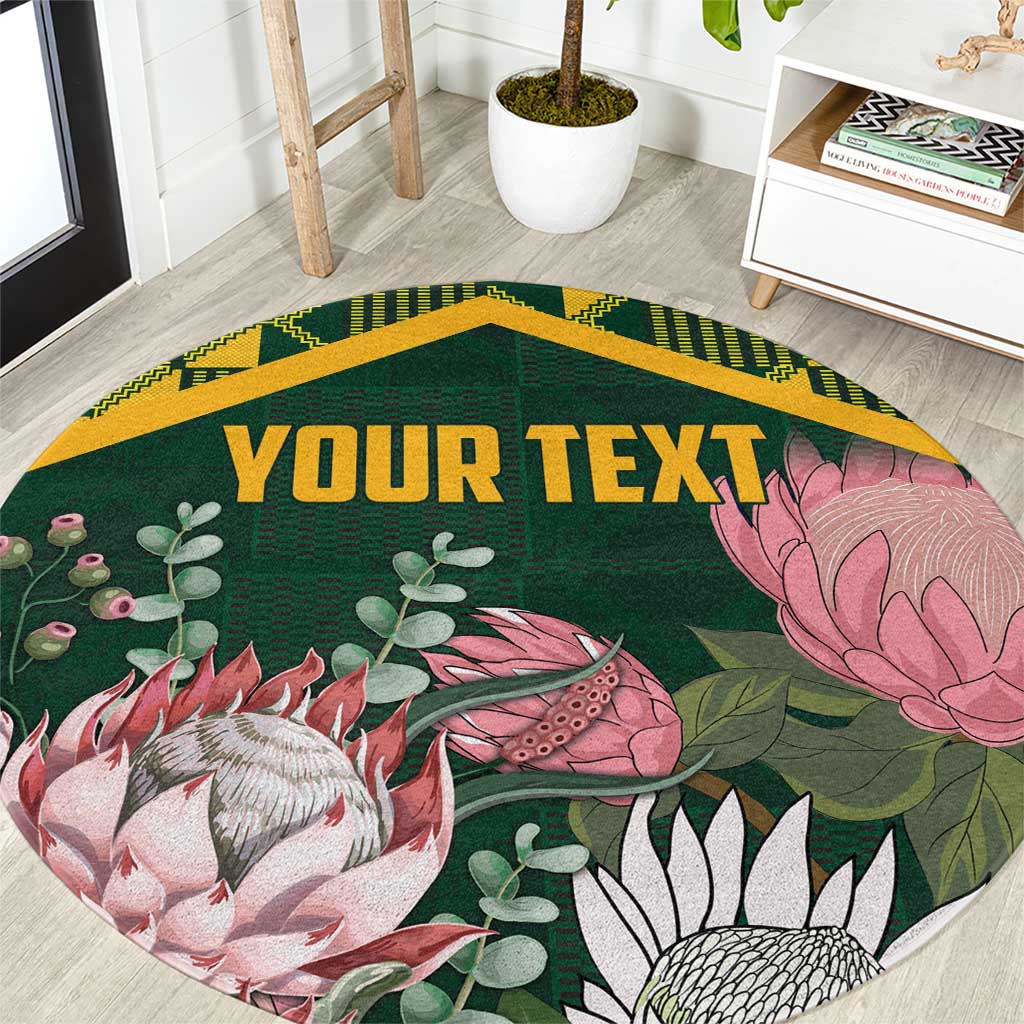 Personalized round green rug with gold kente-style border and floral protea design