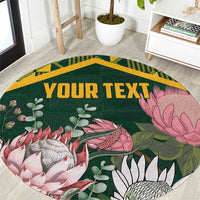Personalized round green rug with gold kente-style border and floral protea design