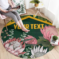 Round green area rug with gold border, floral protea graphics, and custom text banner