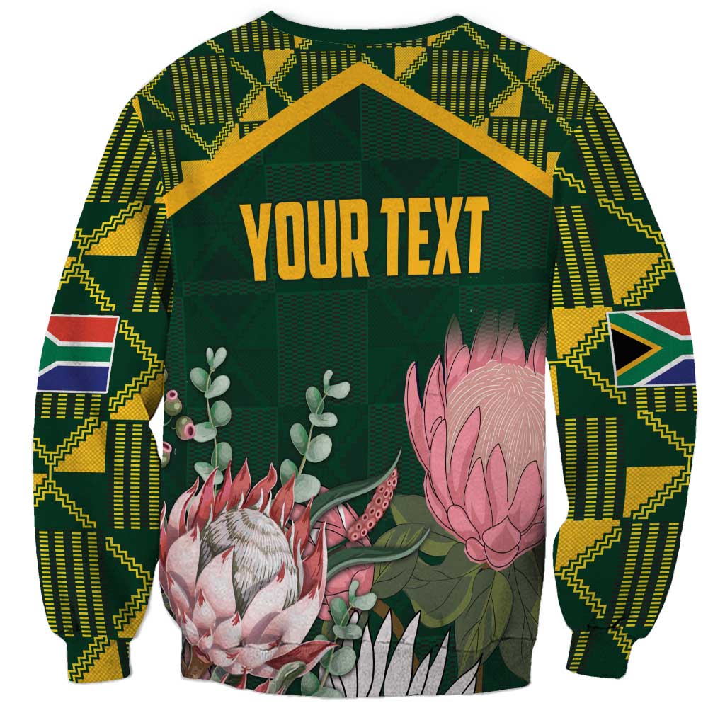 Green unisex sweatshirt with Kente-pattern sleeves and floral protea graphic, “YOUR TEXT”