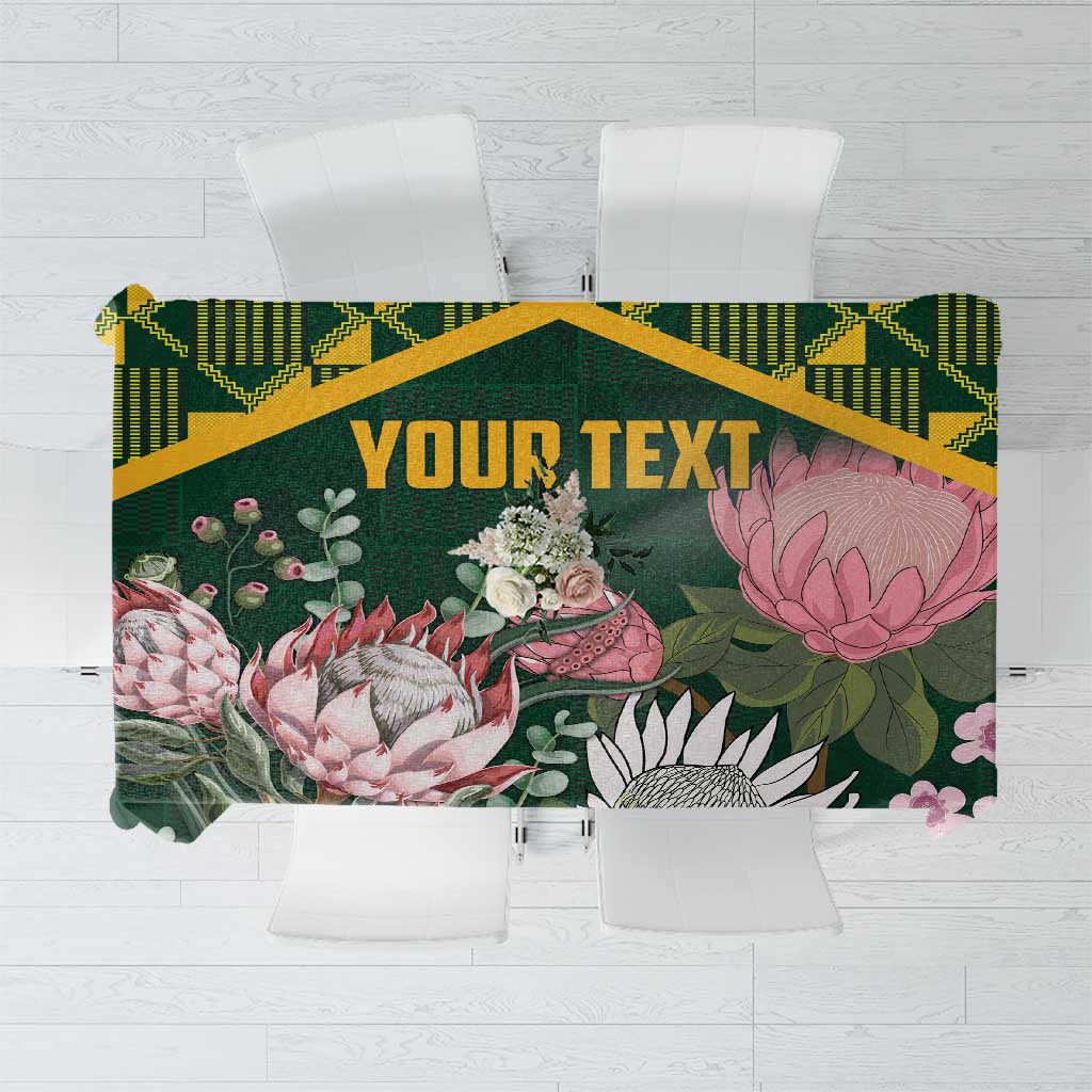 Green tablecloth with floral print, yellow Kente-style border, and centered 'YOUR TEXT'