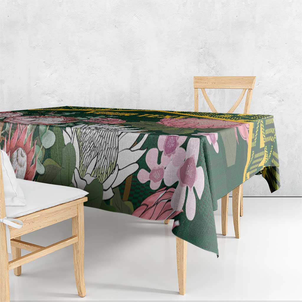 Green floral tablecloth with yellow geometric Kente-style border, draped over table