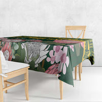 Green floral tablecloth with yellow geometric Kente-style border, draped over table