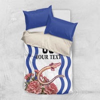 Folded bedding set: white and blue duvet with wavy stripe pattern, pink flowers, blue pillowcases