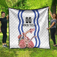White quilt featuring blue wavy emblem, custom text, and pink carnation flowers with dragon.
