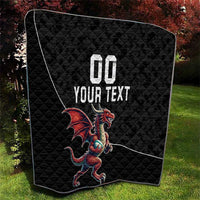 Black quilted blanket with Welsh dragon mascot and custom text, angled close-up