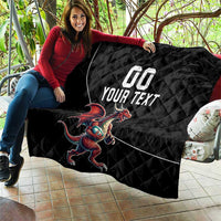 Black quilted blanket with Welsh dragon mascot and custom text, draped on outdoor chair