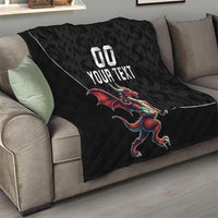Black quilted blanket with Welsh dragon mascot and custom text, laid across sofa