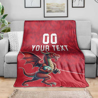 Red rugby blanket with dragon graphic and "YOUR TEXT" over a couch armrest