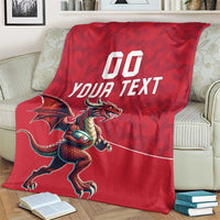 Red personalized rugby blanket draped on a cream couch with dragon mascot design