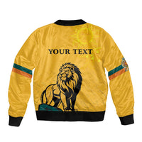 Yellow bomber jacket back with lion graphic, sun face emblem, 'YOUR TEXT', ribbed trim