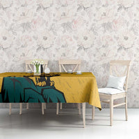 Yellow tablecloth with lion and sun-face print, on dining table with chairs