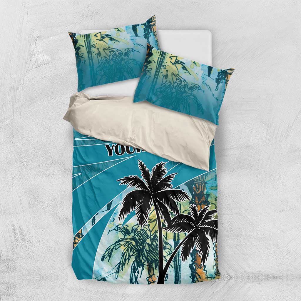Folded blue bedding set with palm tree design and "YOUR TEXT" print on duvet