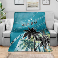 Personalized blue blanket showing large coconut palm tree and 'YOUR TEXT' on sofa