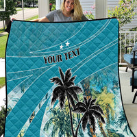 Blue quilt with quilted diamond pattern, palm tree print, and "YOUR TEXT" center