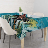 Blue tablecloth with tropical palm leaf print, neatly spread over a dining table
