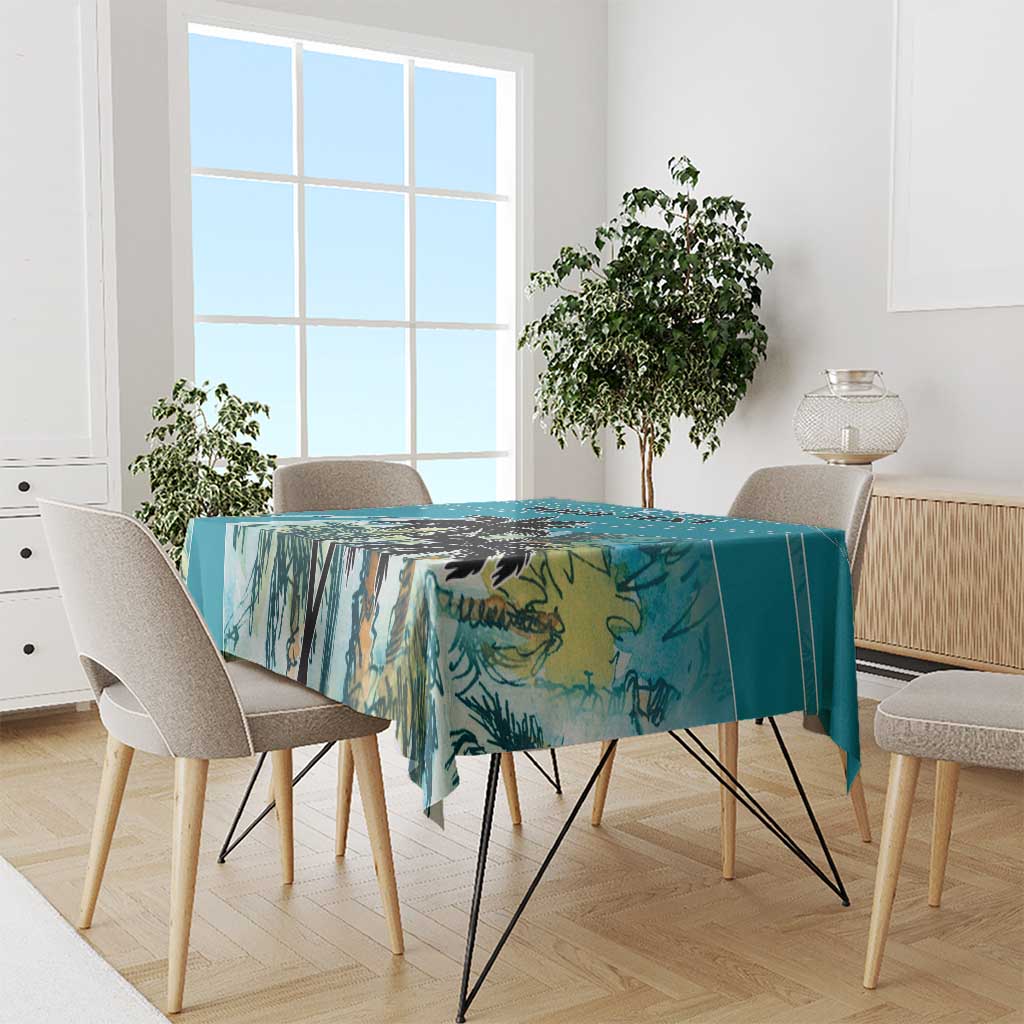 Blue tablecloth with tropical palm leaf print on a dining table with chairs
