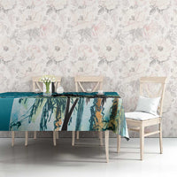 Blue tablecloth with tropical palm leaf print, spread across a dining table