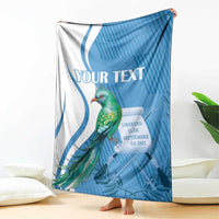 Blue and white personalized throw blanket with quetzal bird and decorative ribbon
