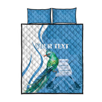 Blue quilt and two pillowcases with quetzal bird motif and decorative text