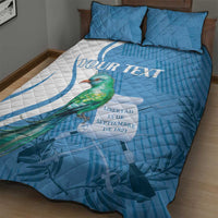 Blue and white quilt bed set with quetzal bird artwork, sweeping emblem, two pillows