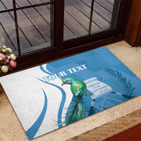 Personalized blue rubber doormat showing quetzal bird with illustrated date emblem