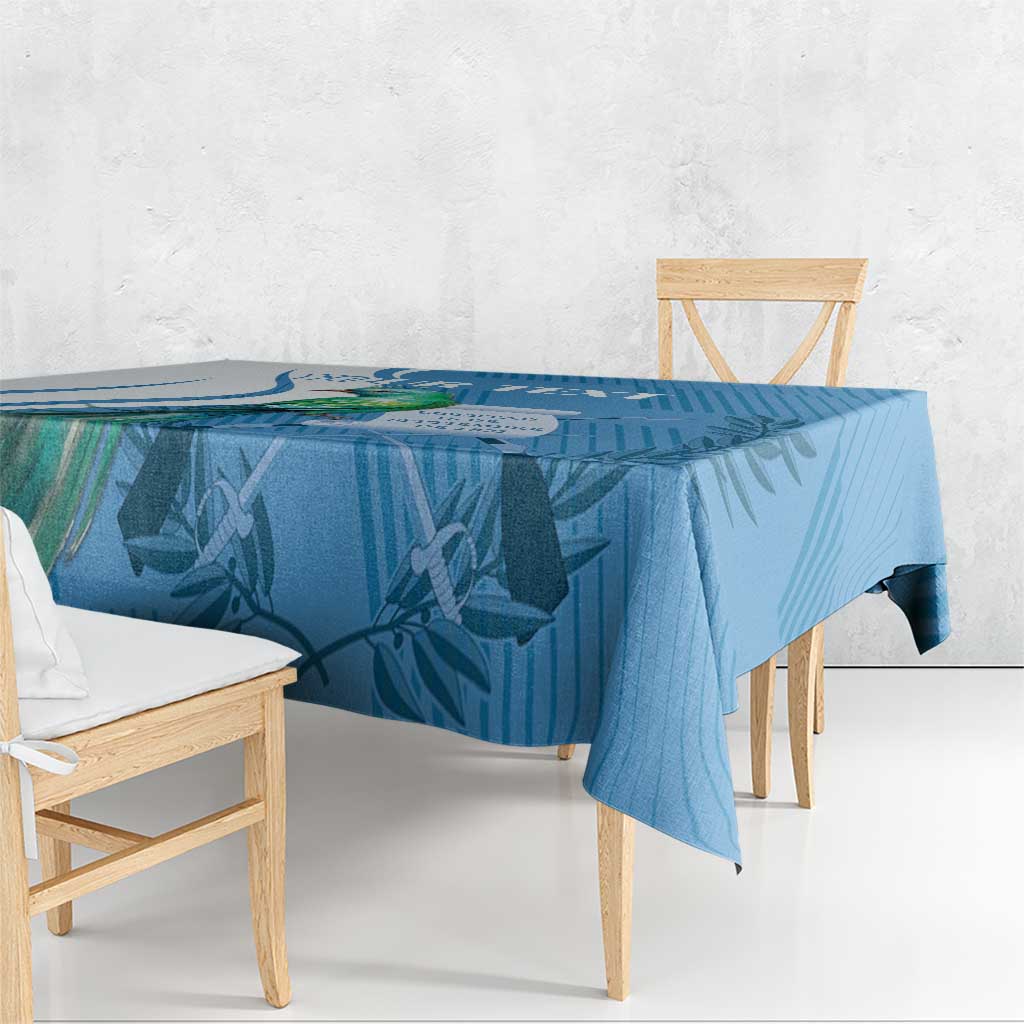 Blue tablecloth with tropical leaf print, draped over a dining table.
