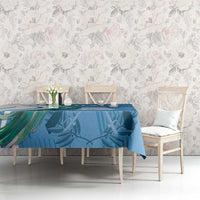 Blue tablecloth with tropical leaf and bird design, spread over a dining table.