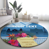 Blue round rug with tropical flowers, YOUR TEXT, and liberty skyline print from wider angle.