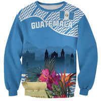 Blue unisex sweatshirt with Guatemala-style city skyline and tropical flower graphic