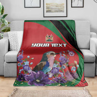 Personalized blanket on sofa: red panel with bird and purple blooms, green and black edges