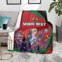 Personalized blanket on couch: bird illustration with purple flowers on red, green and black panels
