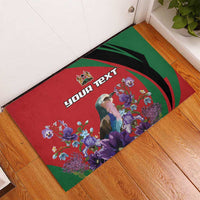 Custom rubber doormat with red center, green border, colorful flowers, and 'YOUR TEXT' wording.