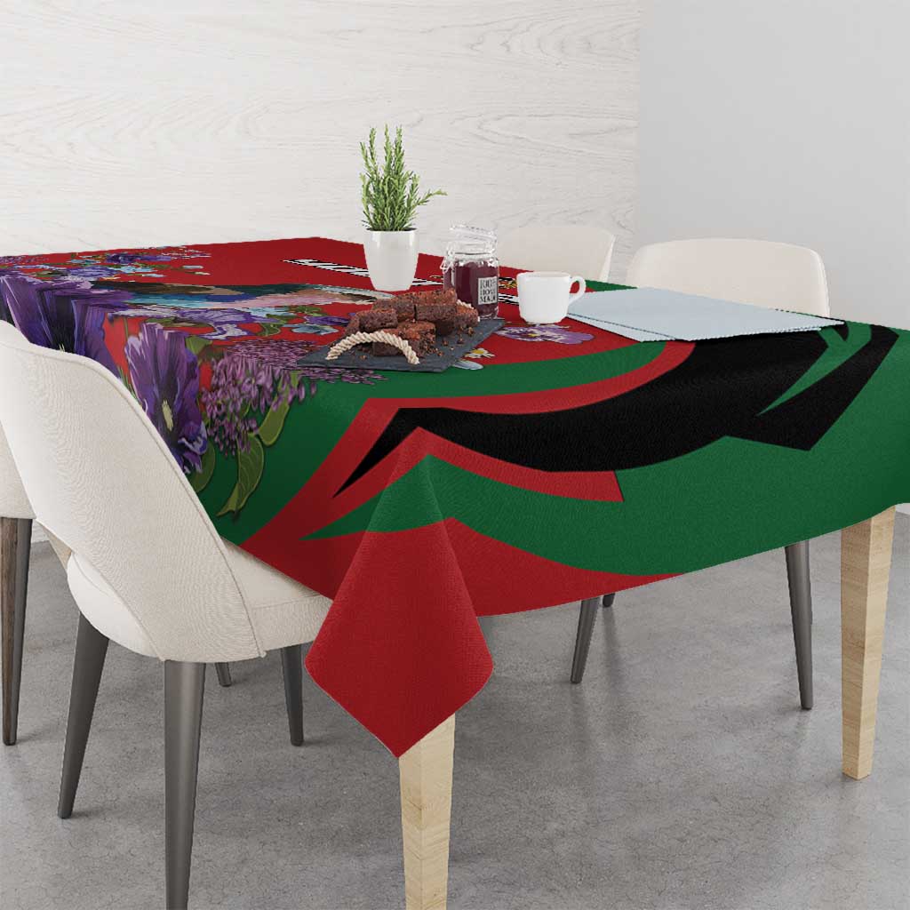 Red tablecloth with green-and-black swoops and purple floral print, draped on dining table