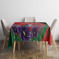 Red, green, and purple floral tablecloth on a square dining table with four chairs