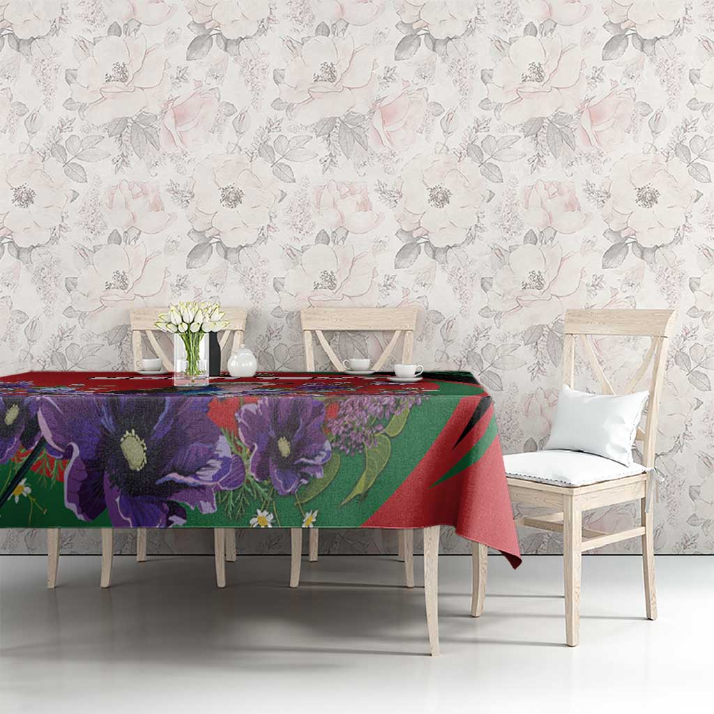 Purple and red floral tablecloth with green accents on dining table with chairs