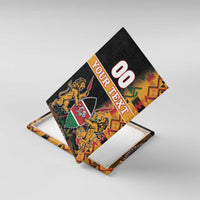 Angled black canvas wall art with kente border, '00 YOUR TEXT', lions and shield