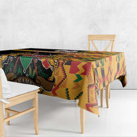 Black kente-pattern tablecloth with coat of arms, draped over table edge.