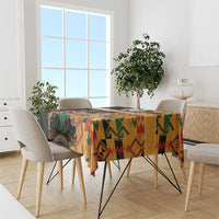Black kente-pattern tablecloth with coat of arms, draped on dining table.