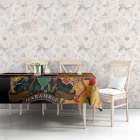 Black kente-pattern tablecloth with coat of arms and 'HARAMBEE' text, on sideboard.