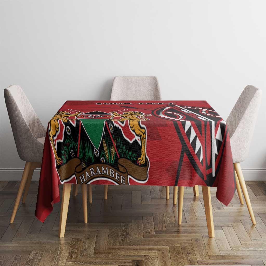 Red tablecloth with HARAMBEE text, coat-of-arms graphic, and colorful tribal design